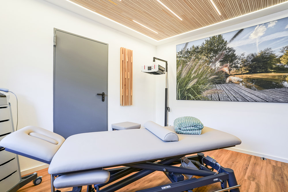 PhysioVITAL Bartels -Behandlungsraum mit Massageliege und Naturbild an der Wand